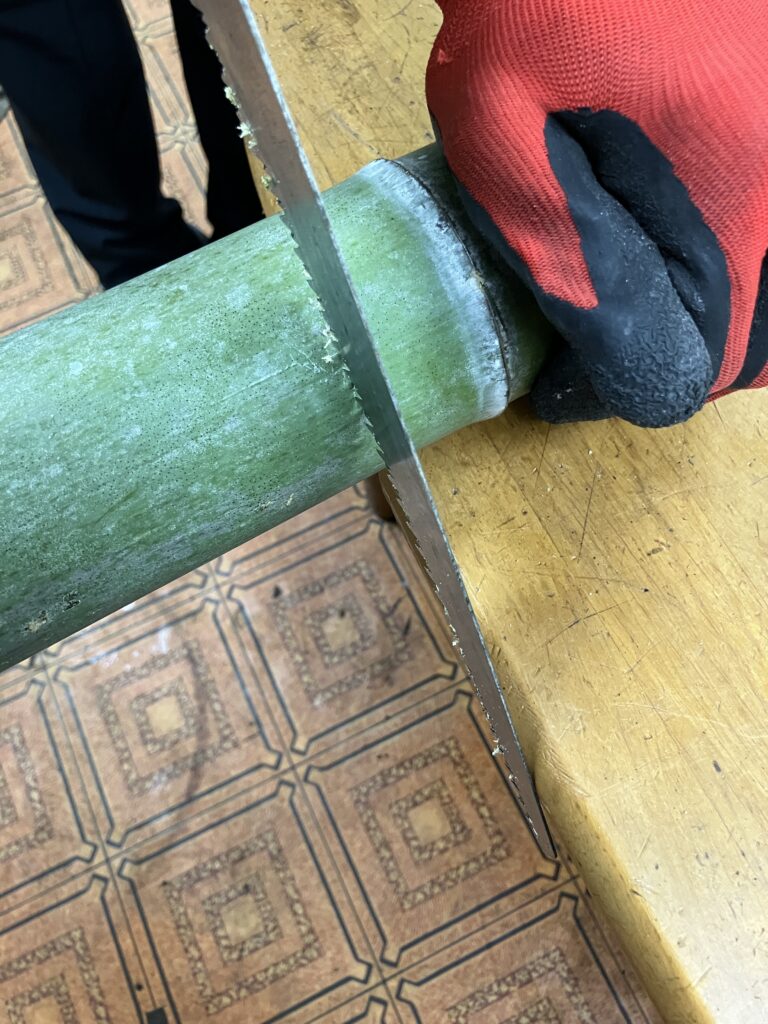 背負子(しょいこ)の骨組み用に竹をノコギリで玉切りしている作業工程