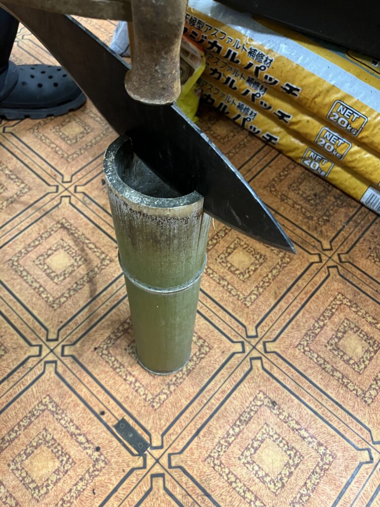 背負子(しょいこ)の材料にするためククリナイフで竹を縦割りしている様子