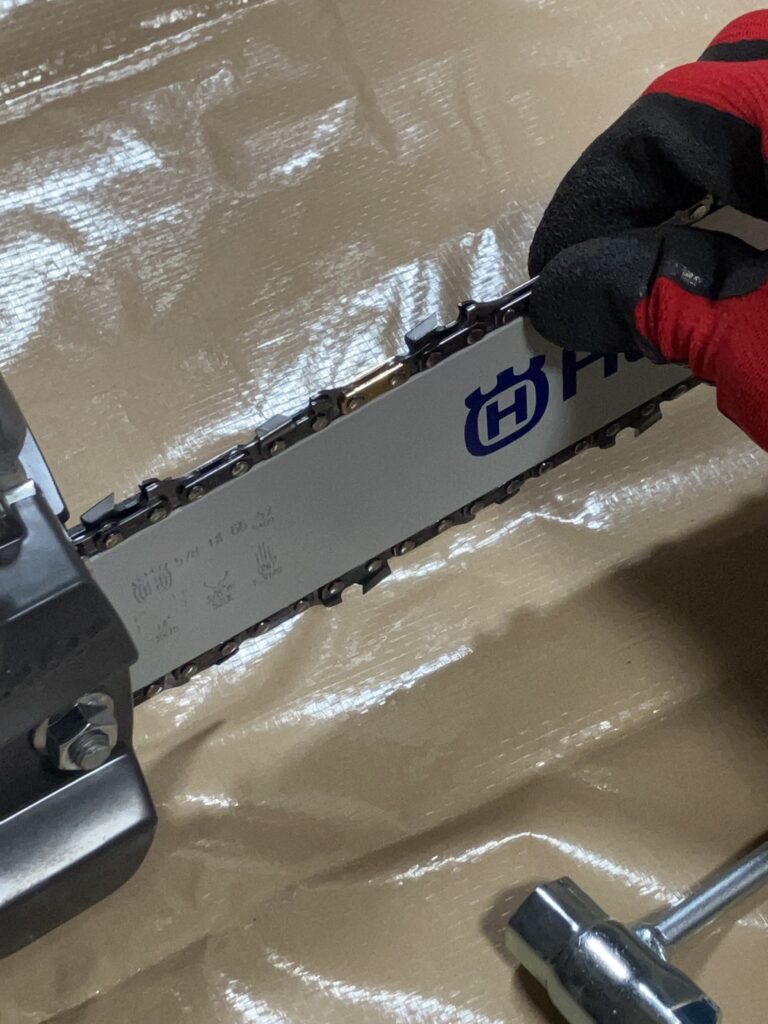 ハスクバーナ135MarkⅡのチェーンのテンションを調整後にチェーンを手で動かして動作確認をしている様子。