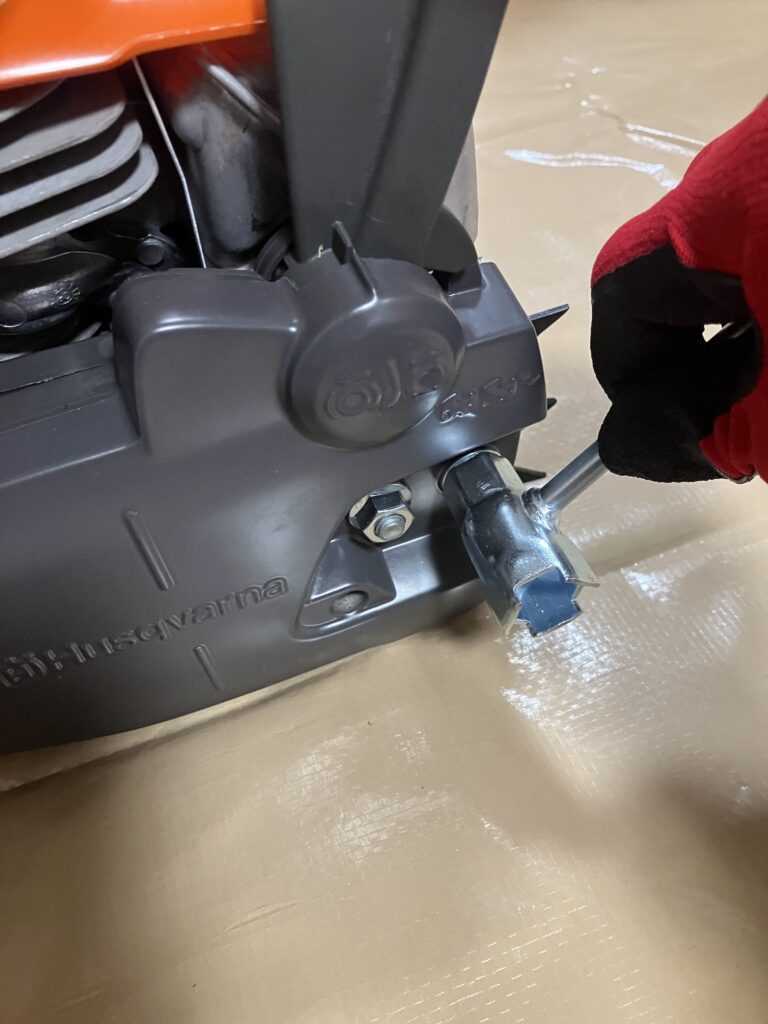 ハスクバーナ135MarkⅡの駆動部カバーを付属レンチで取り外す作業中。チェーンソー組み立て工程の最初のステップ。