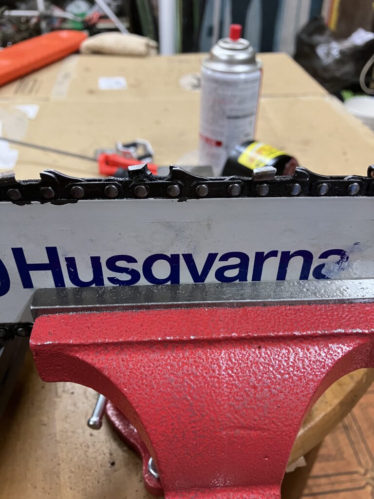 ハスクバーナ135MarkⅡのガイドバーをバイスに固定している様子。