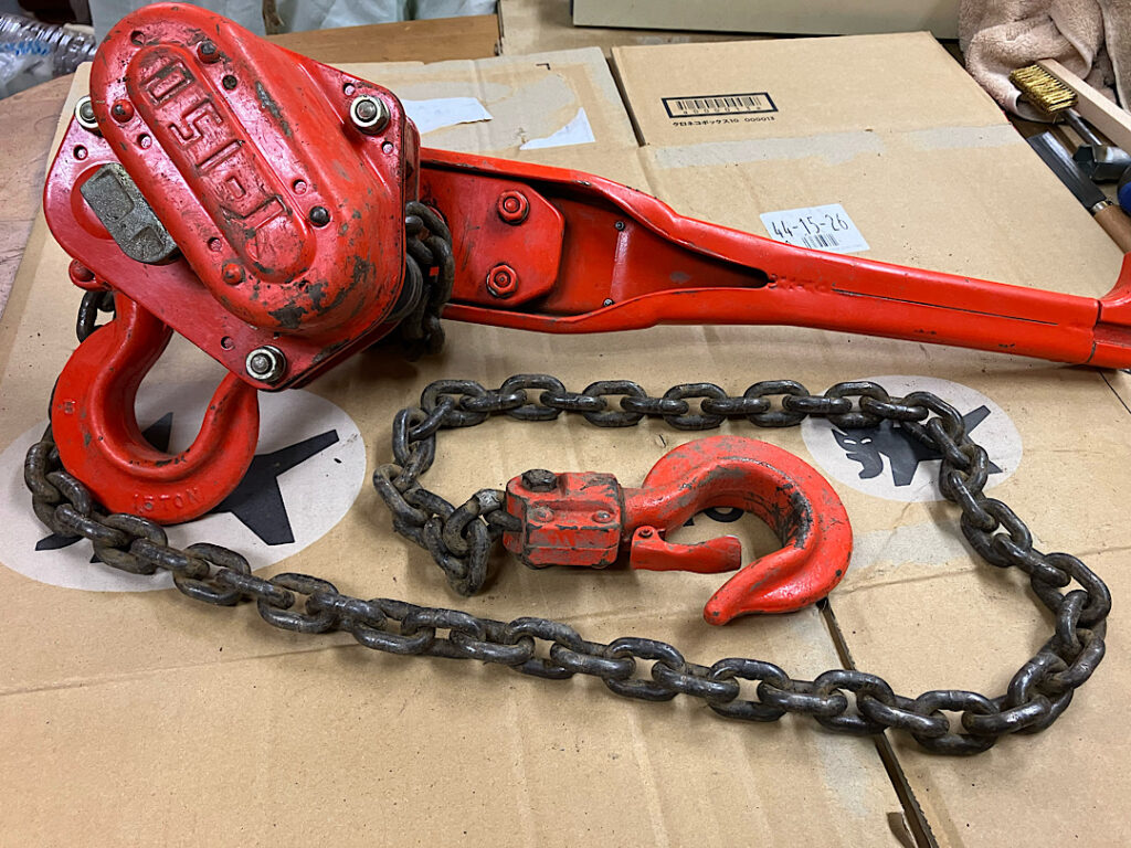 錆びたレバーホイストのチェーン。雨に濡れて放置したことで赤錆が発生した状態の写真。