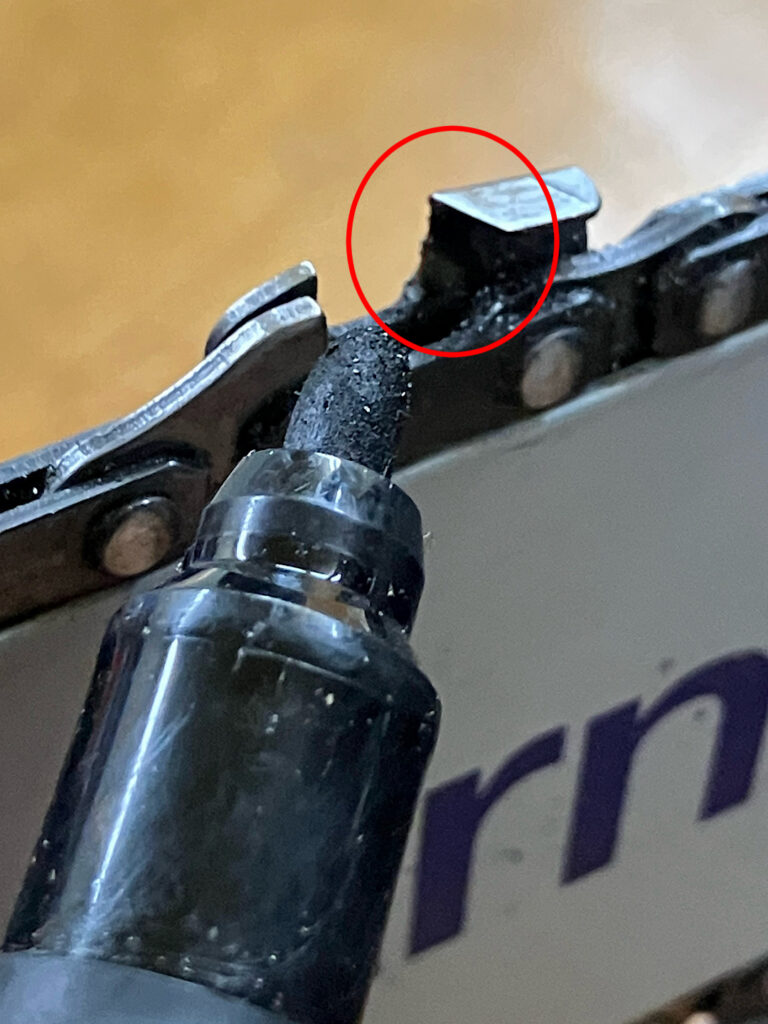 チェーンソー刃の研ぐ部分にマジックを塗って、目立ての研磨範囲を可視化している写真。