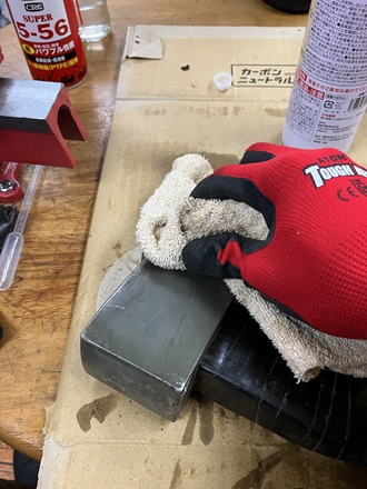 水を含ませたウエスでラストリムーバーを拭き取り、表面を中和している作業写真。