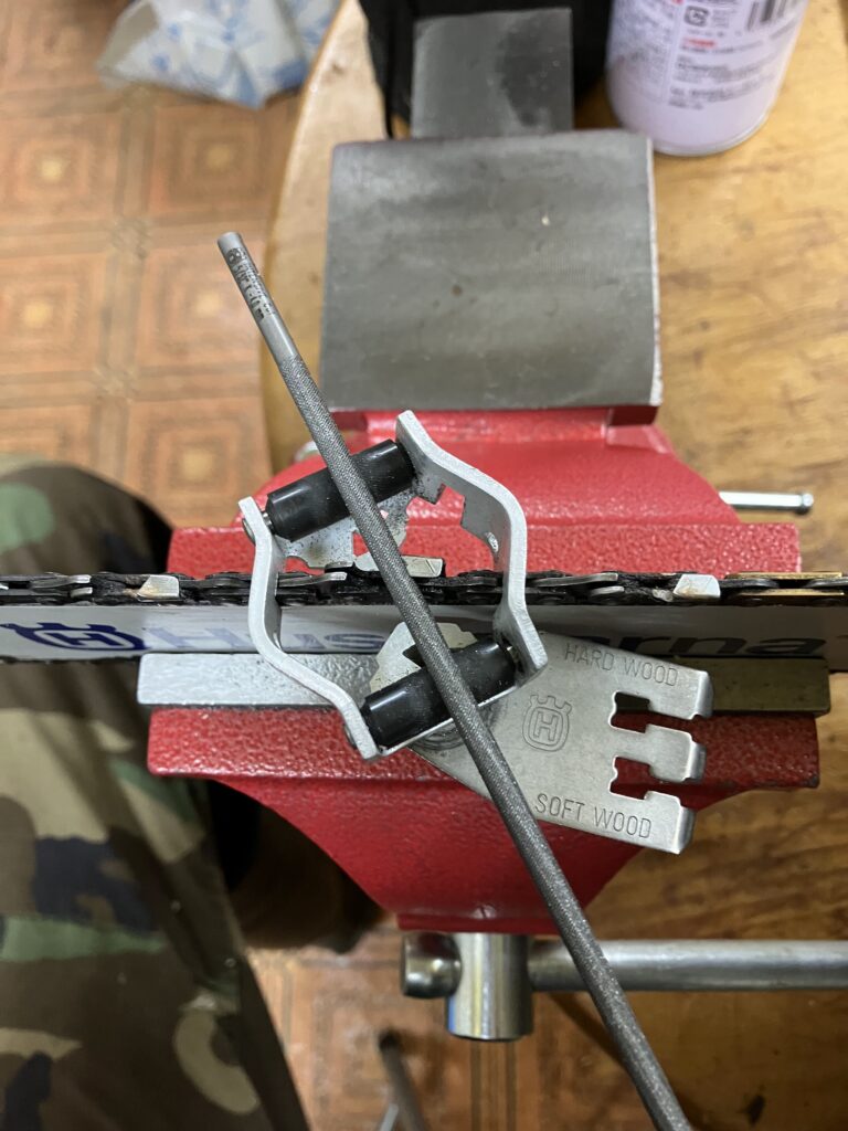 ハスクバーナ純正目立てキットを使ってチェーンソーの刃を研いでいる様子。