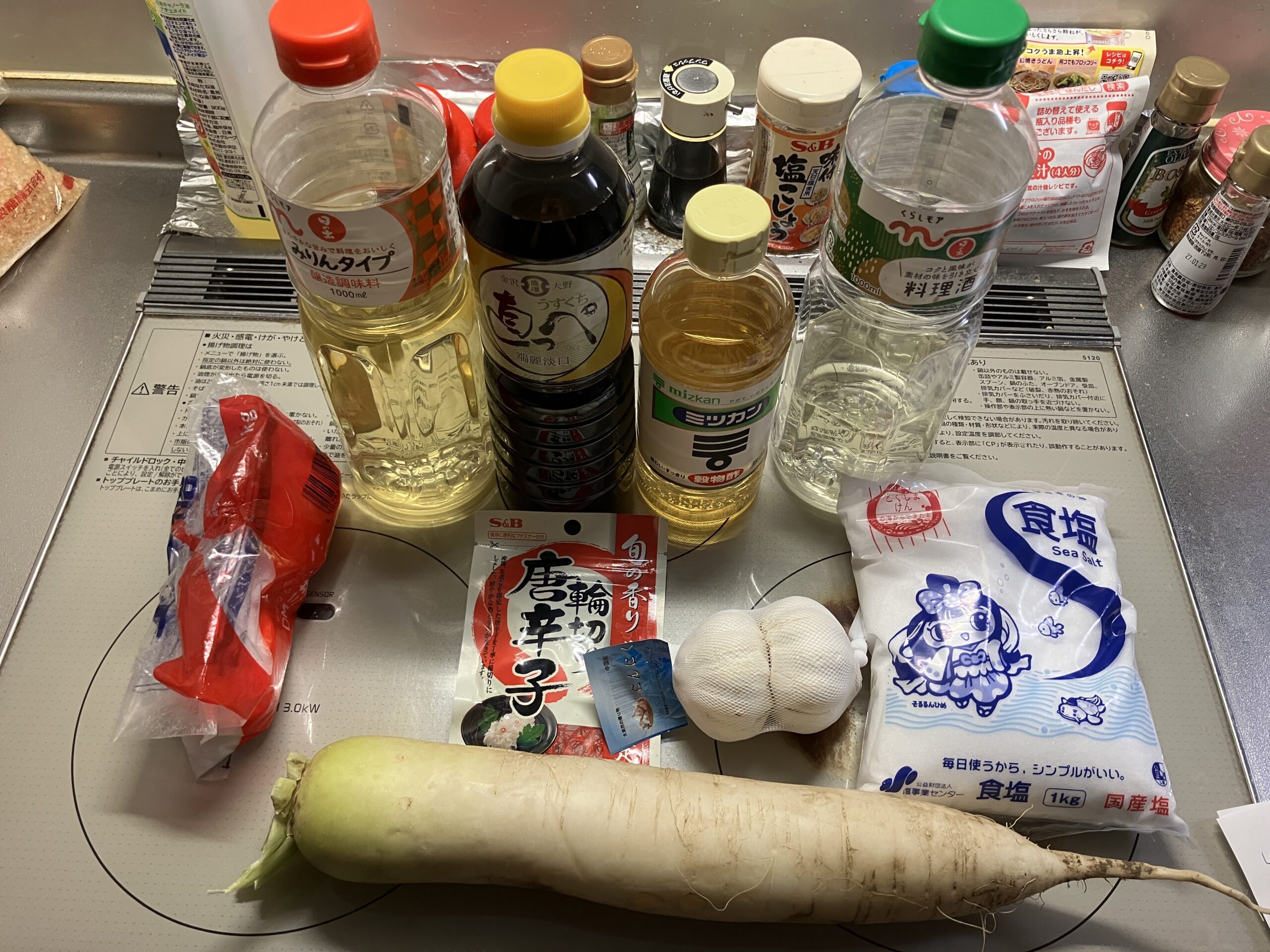 大根の甘辛醤油漬けに使う材料一式（大根、醤油、酒、お酢、砂糖、出汁、みりん、にんにく、鷹の爪）