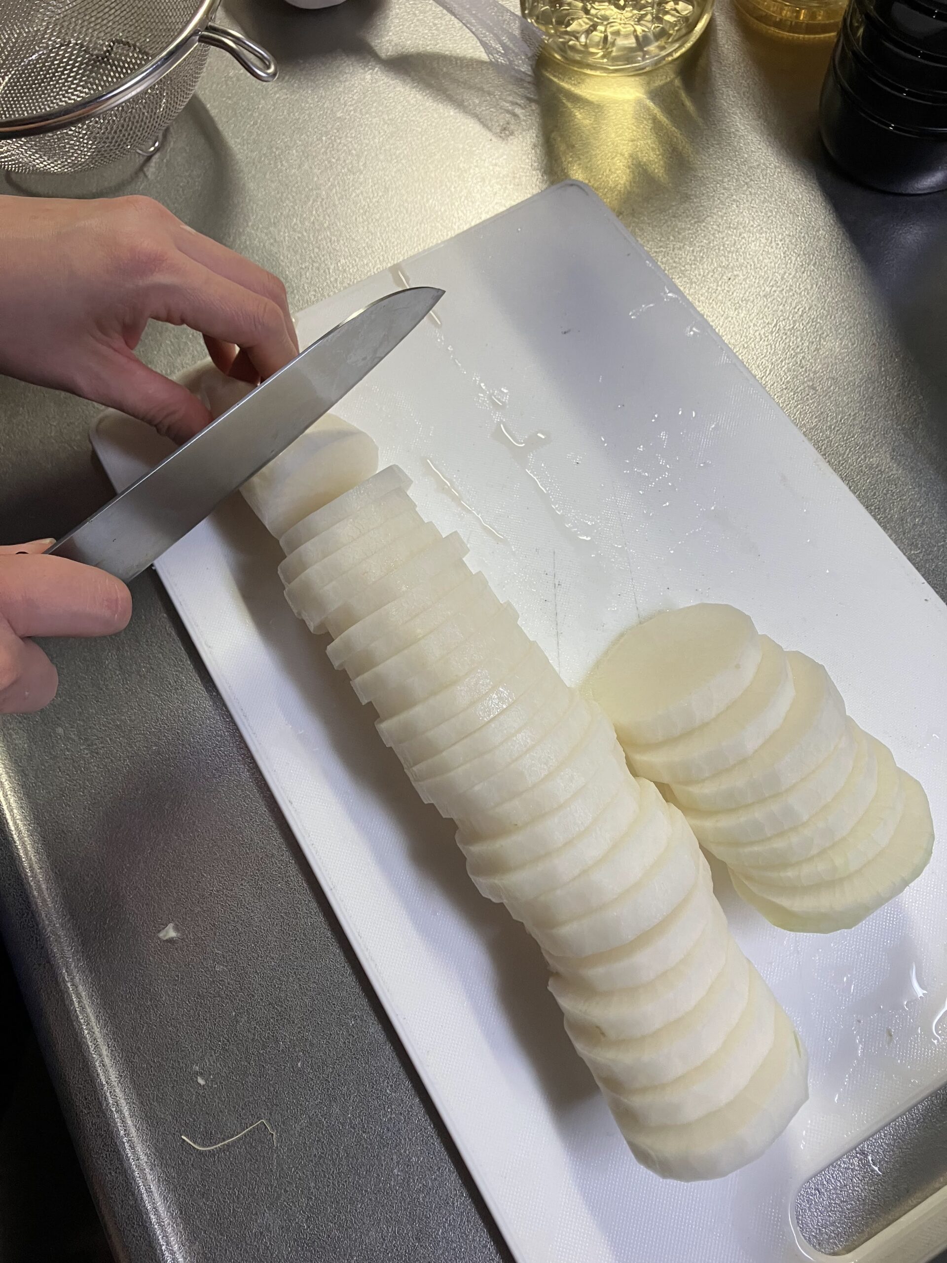 大根の甘辛醤油漬け用に大根を5ミリ厚で輪切りにしている様子