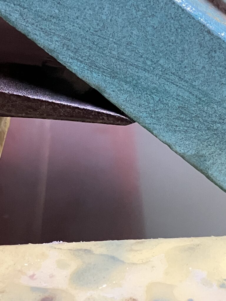 斧の刃先に砥石を当ている様子。