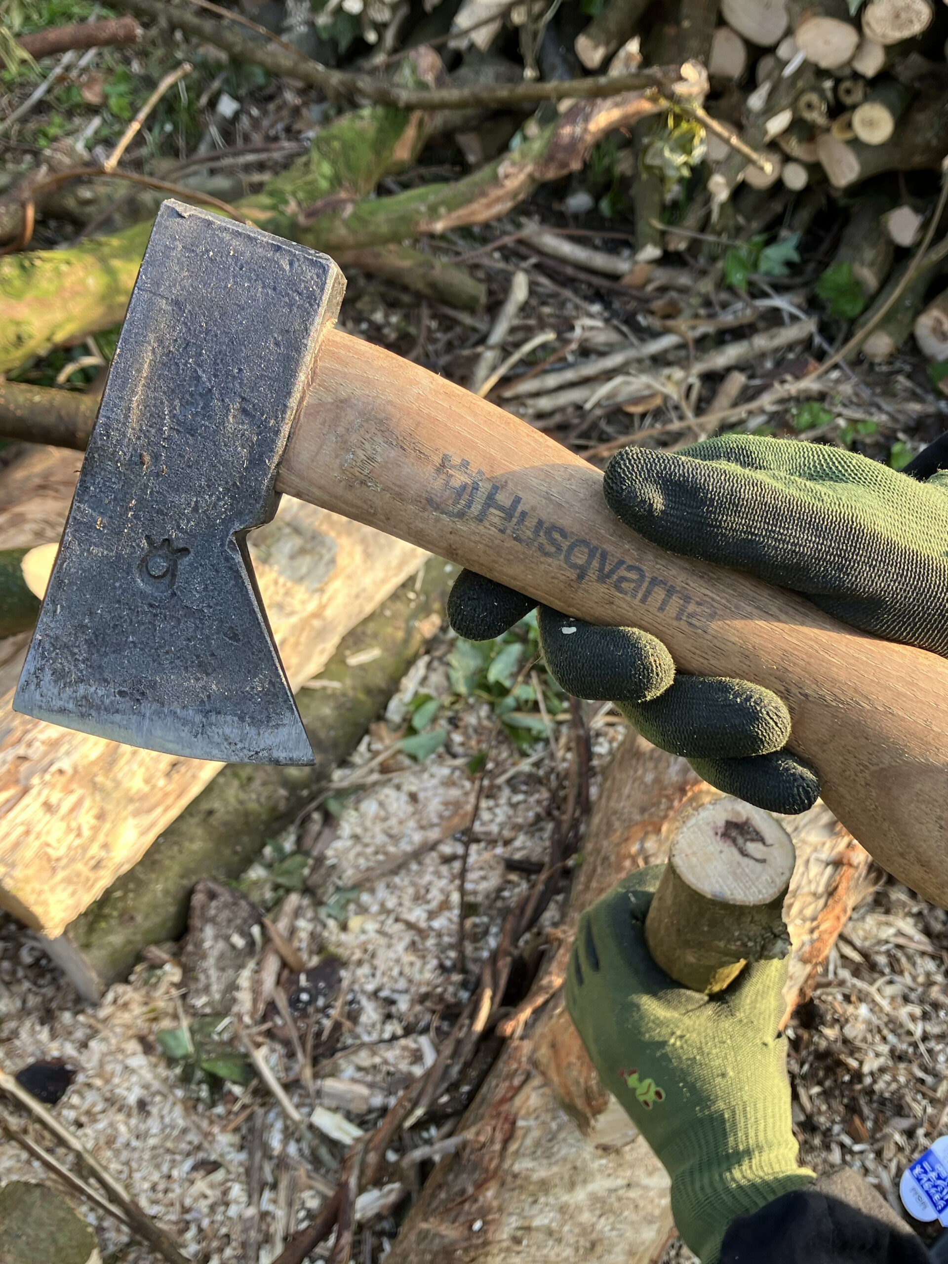 ハスクバーナの小型斧を使って軽く薪を割る女性の使用イメージ