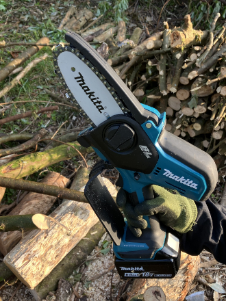 マキタMUC101DRGハンディチェーンソーを片手で持って剪定している軽量モデルの使用イメージ