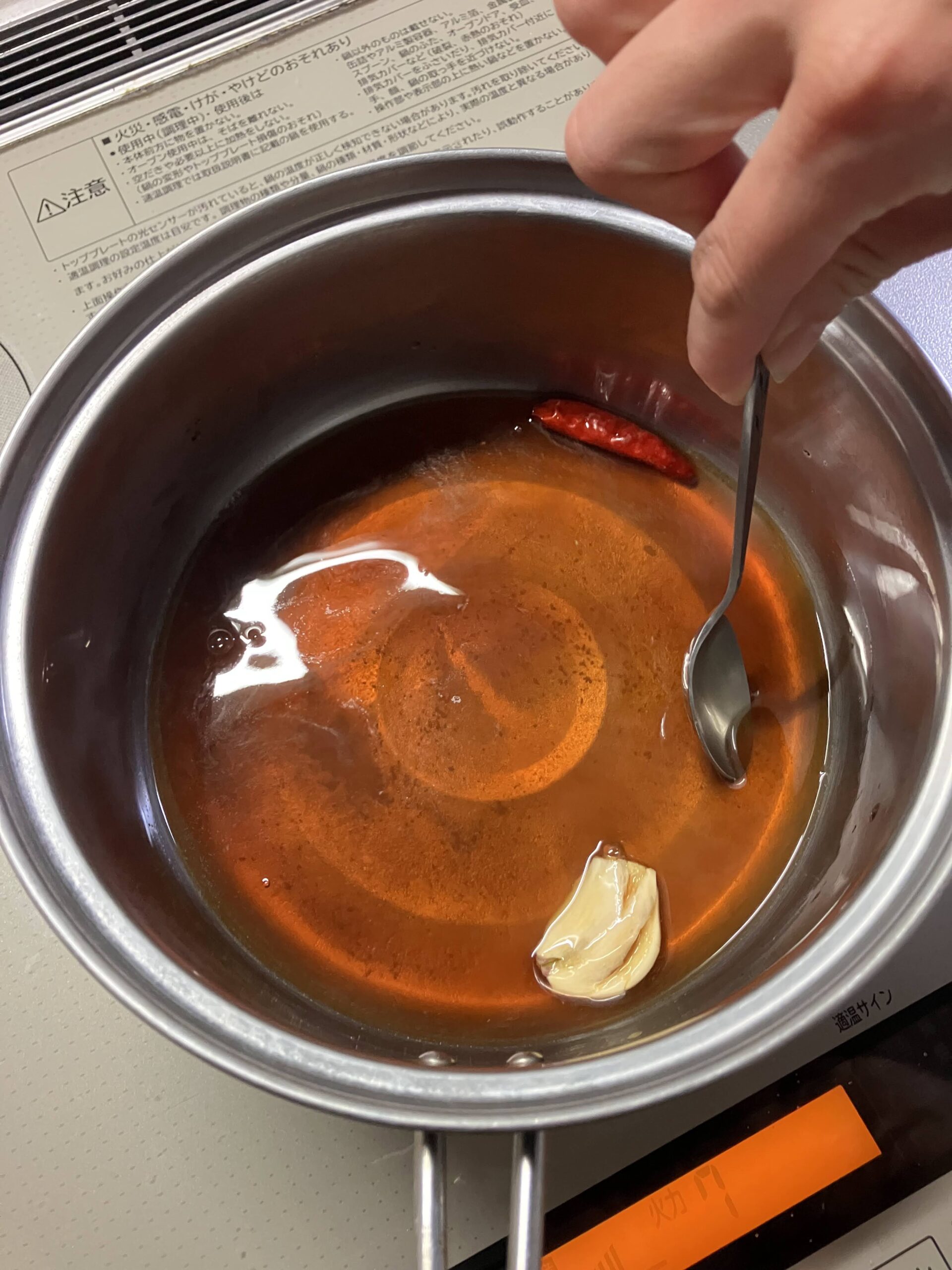 甘辛醤油ダレを火にかけて砂糖を溶かしながら混ぜている工程
