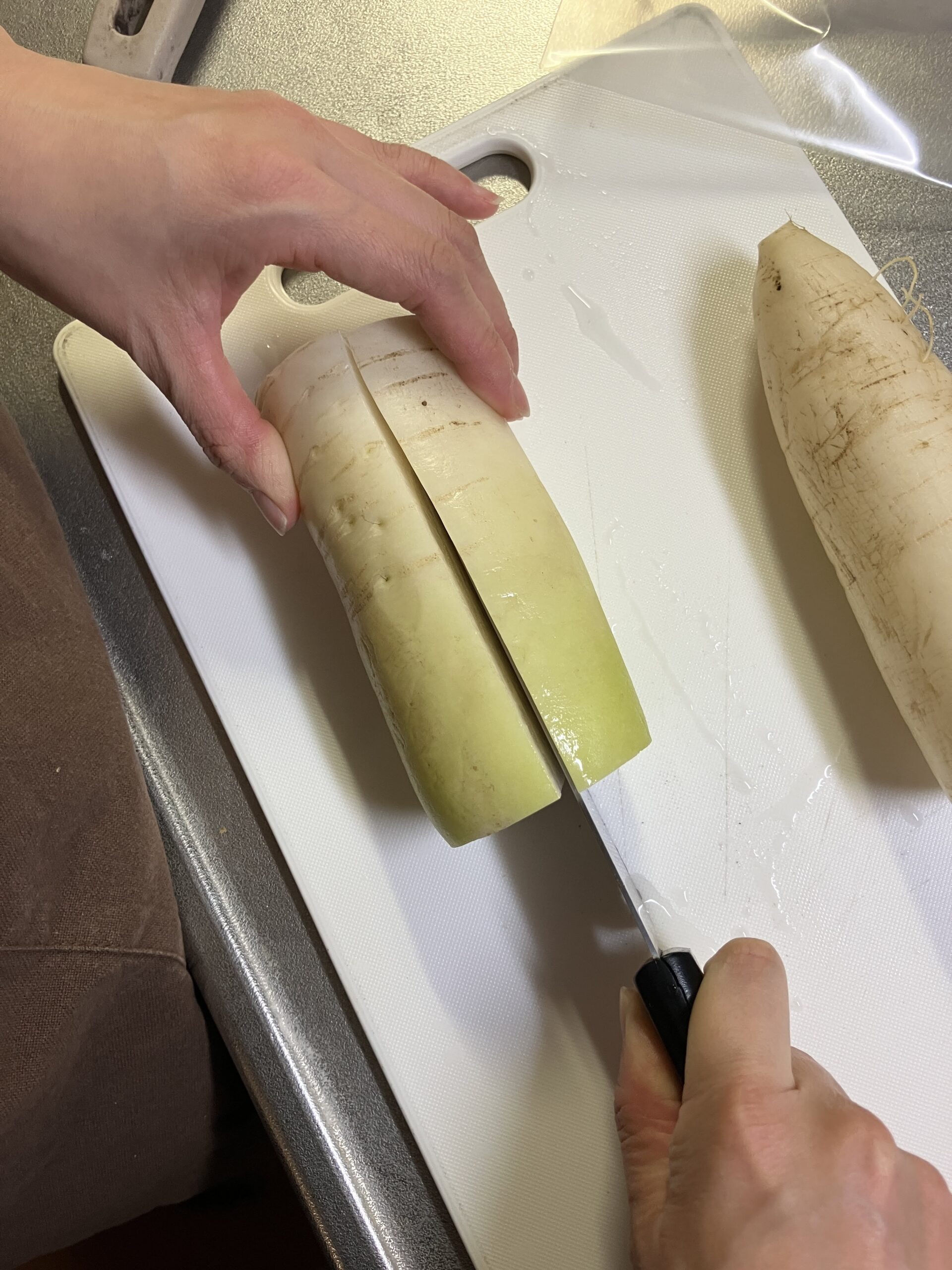 ヘルシーたくあん用に大根を半月切りにしている工程
