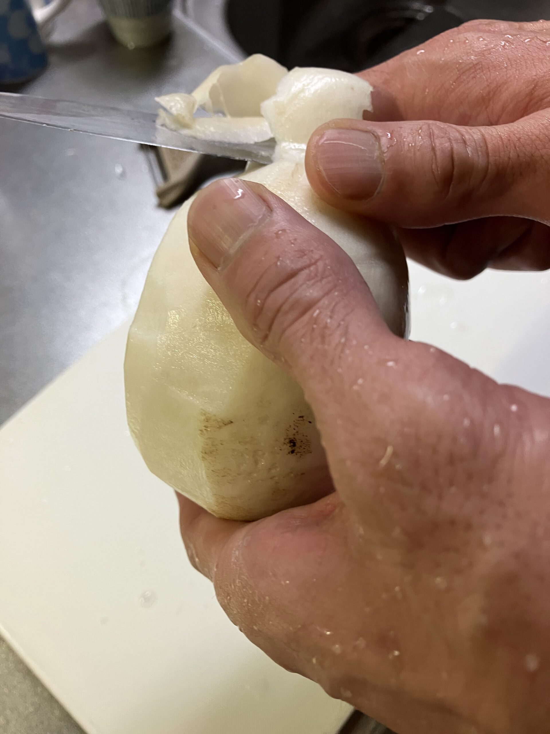 千枚漬け用にカブの皮と葉を切り落としている下処理の様子
