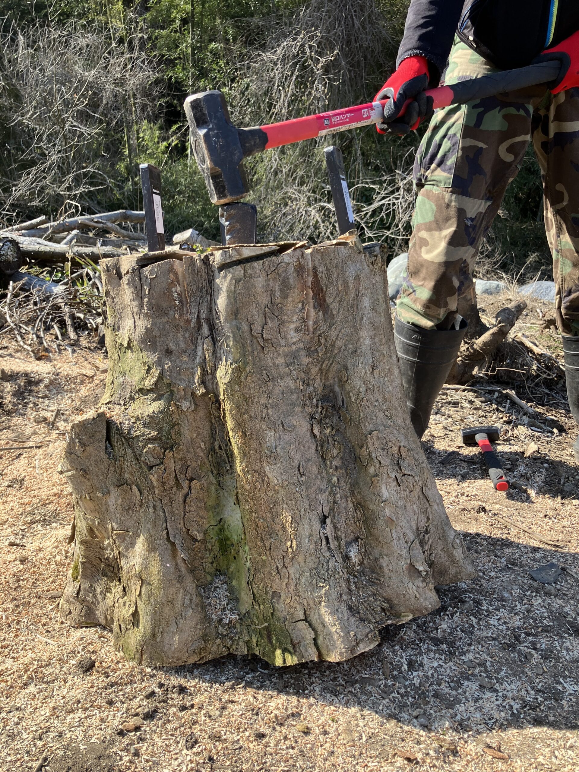 複数のクサビを打ち込みスレッジハンマーで叩いている様子