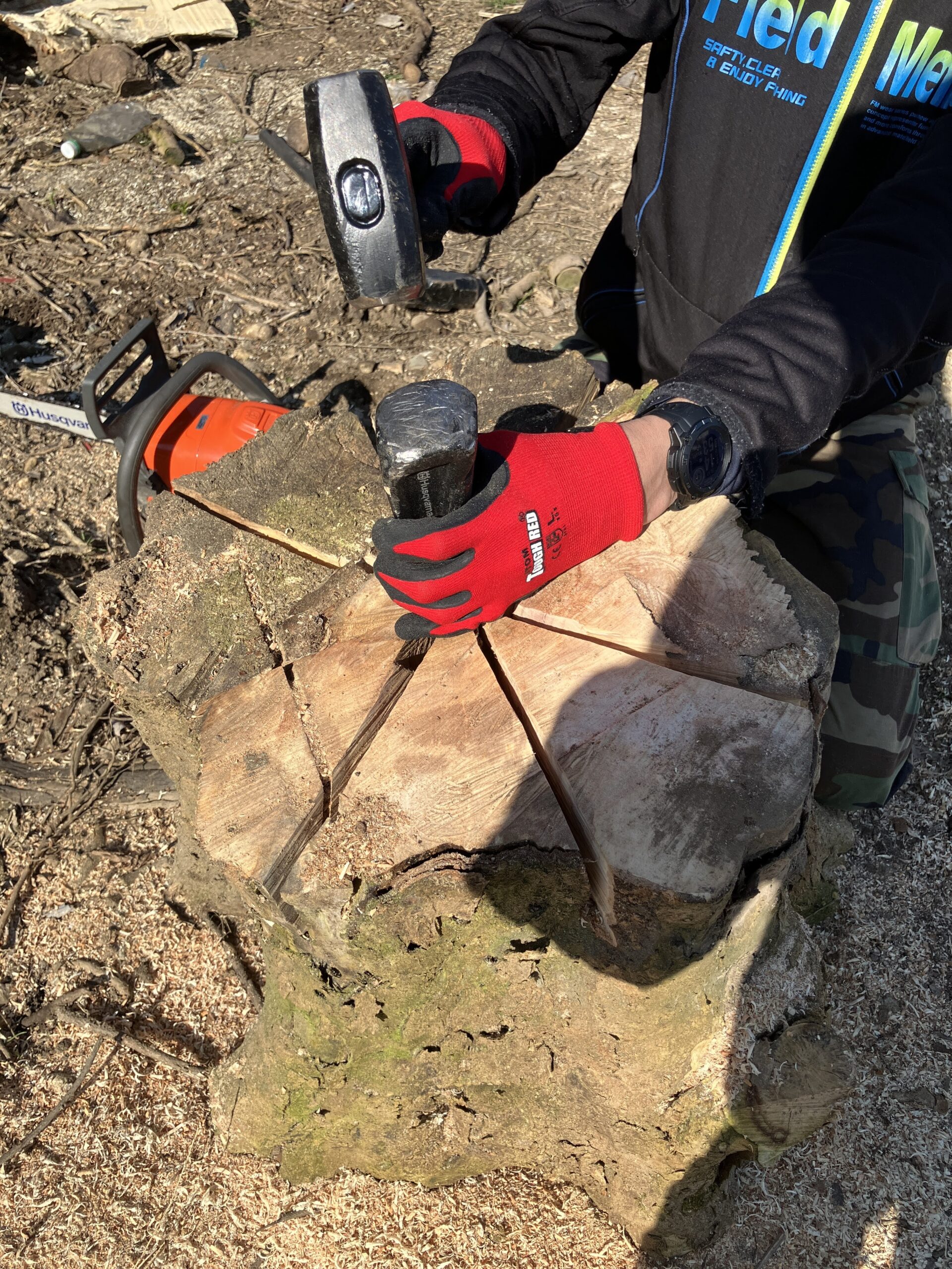 丸太の中央に捻りクサビを打ち込んでいる様子