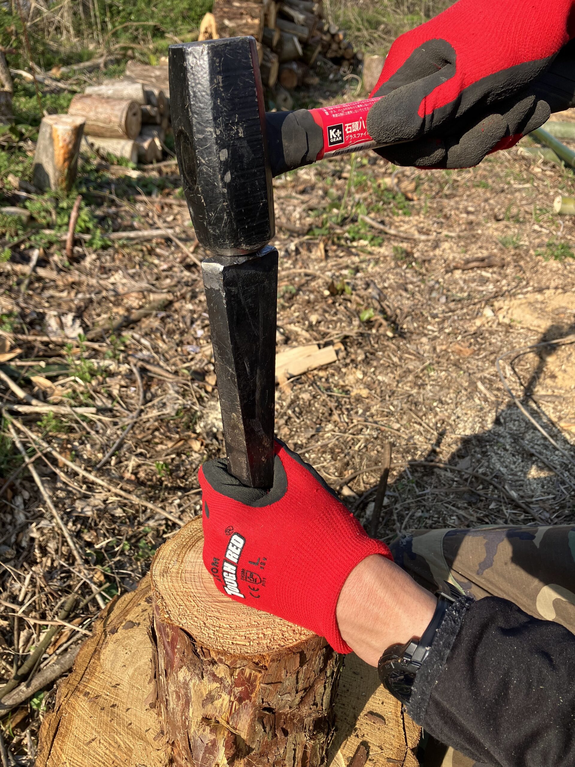 ハルタホースのクサビをハンマーで丸太に打ち込んでいる様子