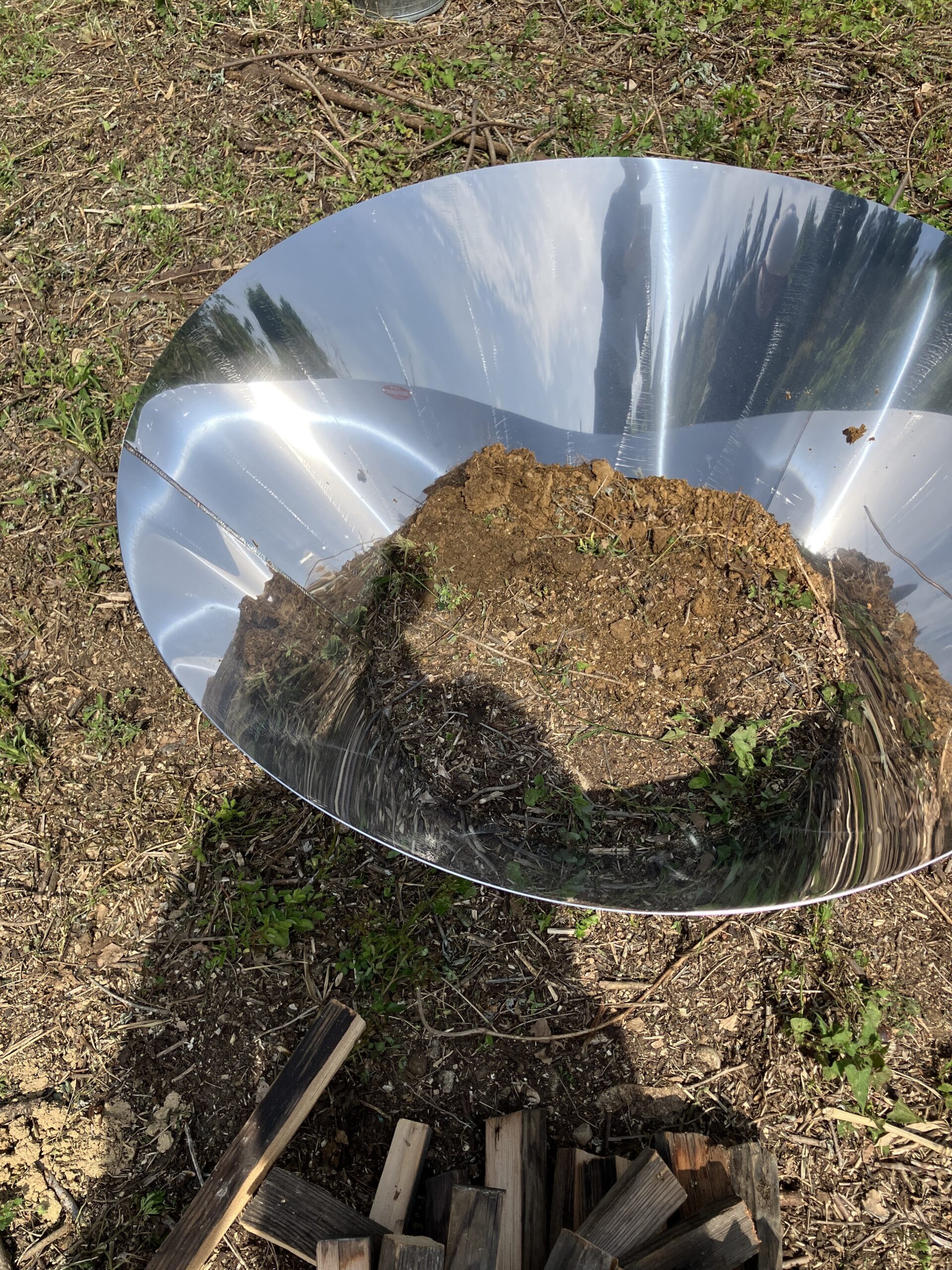 無煙炭化器と地面の隙間を土で埋める作業