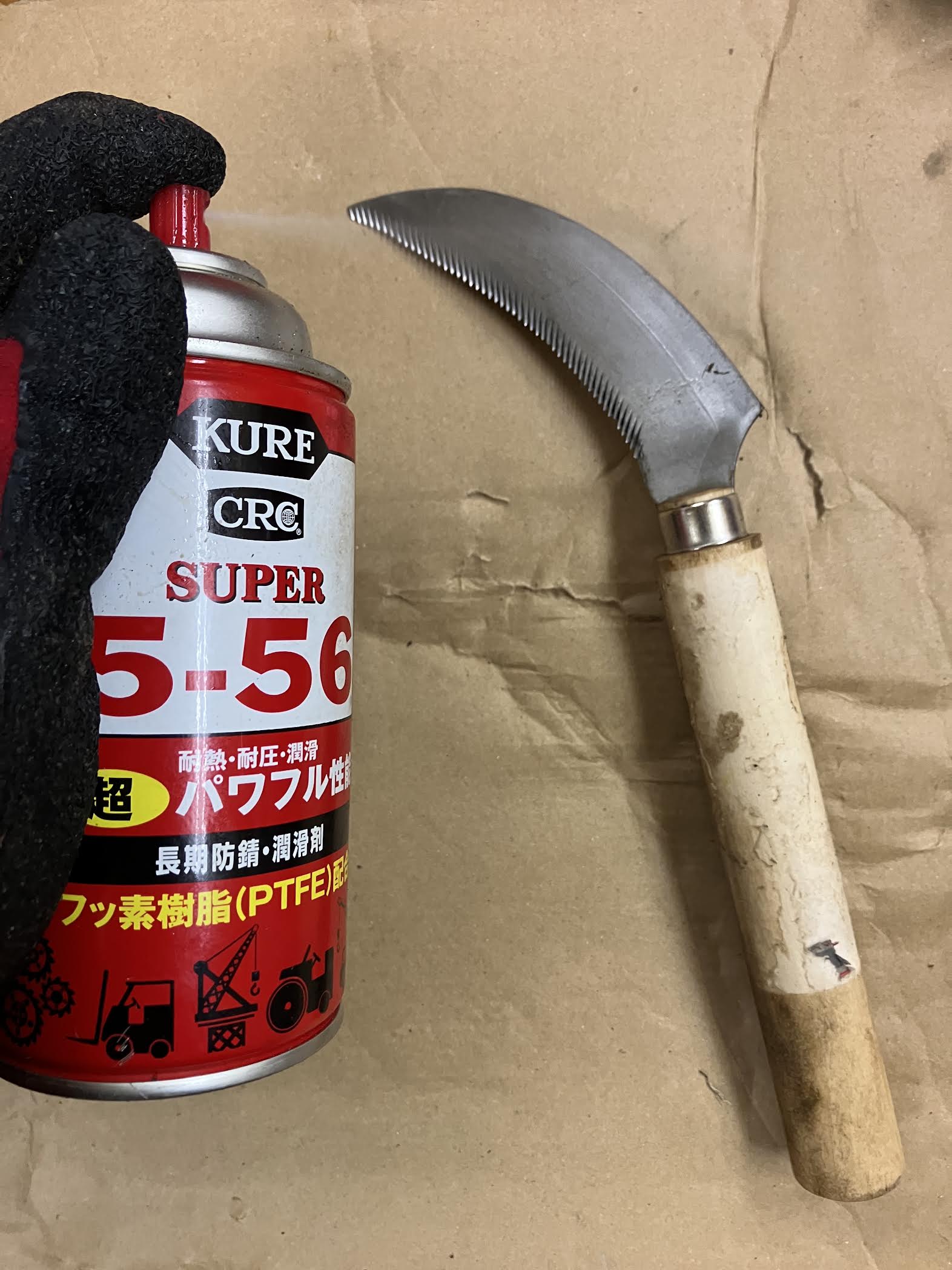 KURE5-56で草取りノコギリ鎌をメンテナンスしている様子